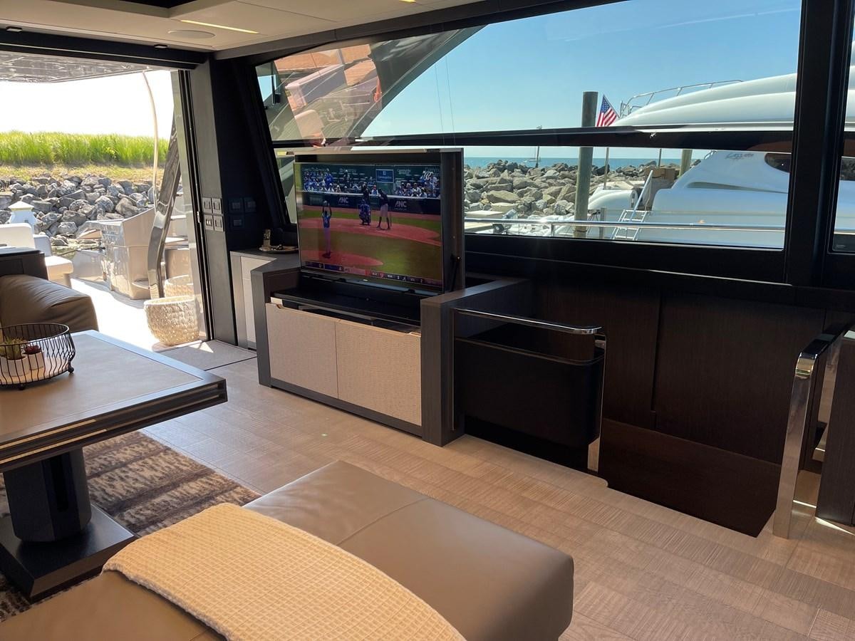 a living room with a large flat screen television and a table aboard NICKY D Yacht for Sale