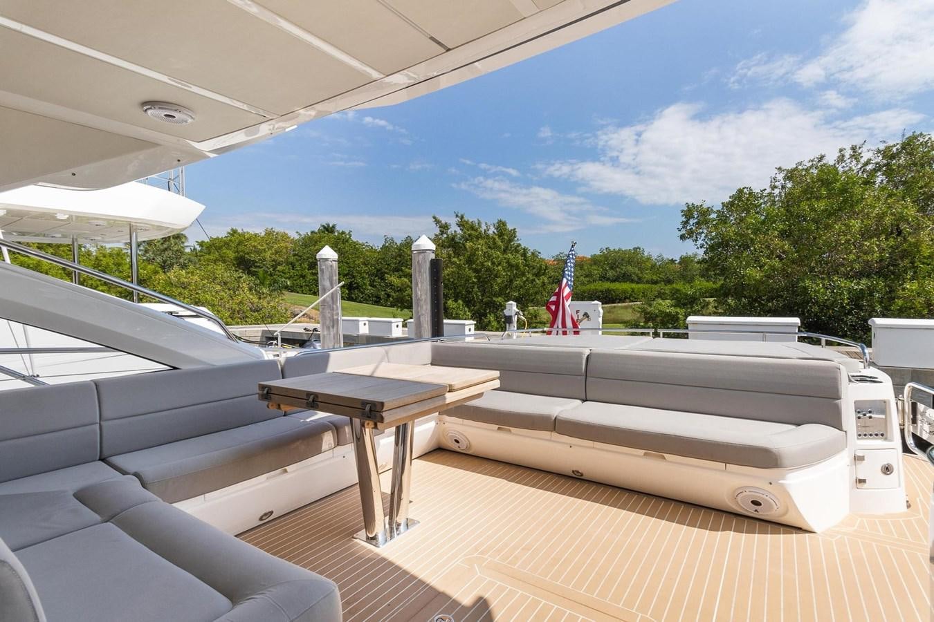 a deck with a table and chairs aboard JOLLY ROGERS Yacht for Sale