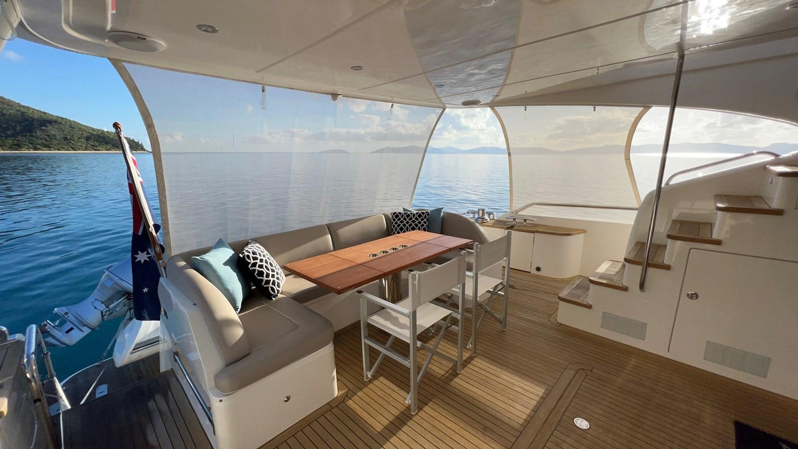 a boat with a table and chairs aboard MOJO Yacht for Sale