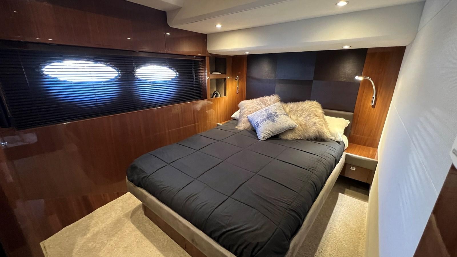 a bed with a blue blanket aboard MOJO Yacht for Sale