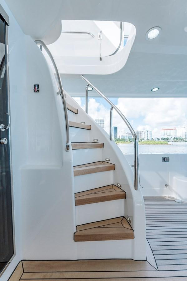 a white boat with a wooden deck aboard FULLY OCCUPIED Yacht for Sale