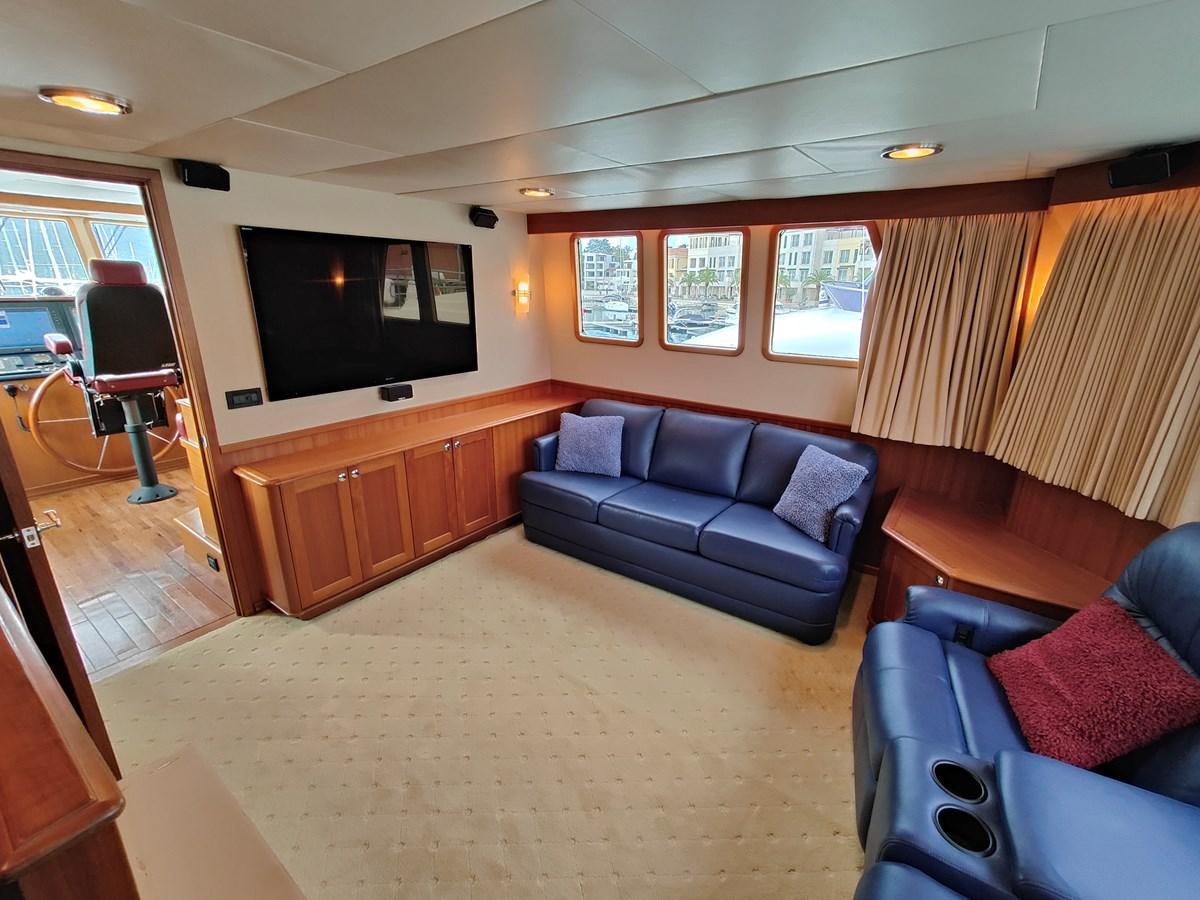 a living room with a couch and a television aboard SPELLBOUND Yacht for Sale