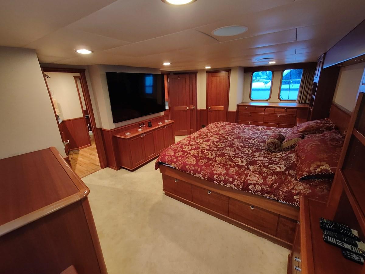 a bedroom with a bed and a tv aboard SPELLBOUND Yacht for Sale