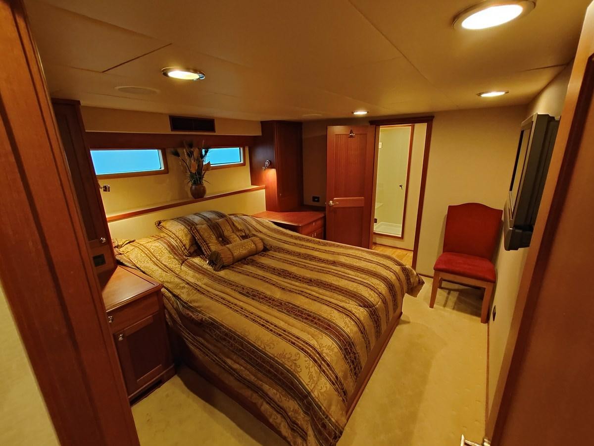 a hotel room with a bed and a chair aboard SPELLBOUND Yacht for Sale