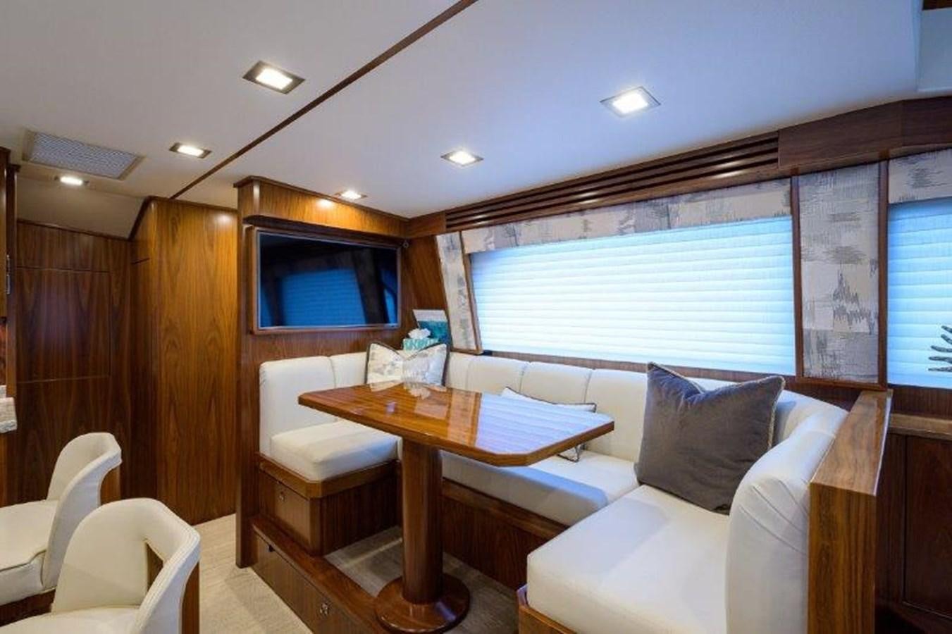 a living room with a table and chairs aboard 50 CALIBER Yacht for Sale