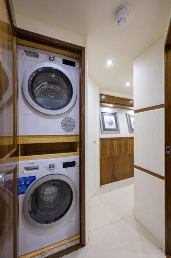 a washing machine and dryer in a room aboard 50 CALIBER Yacht for Sale