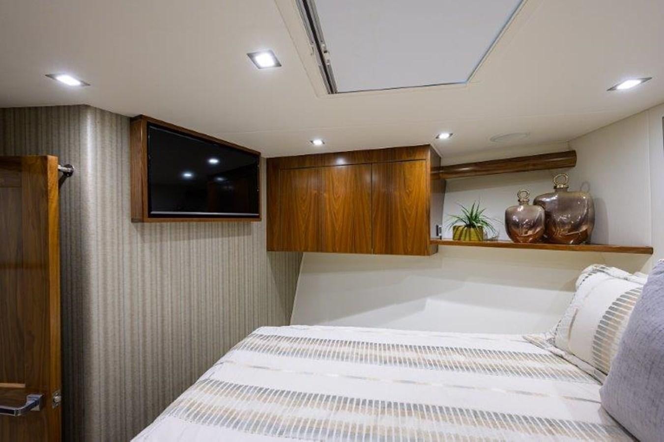 a bedroom with a tv and a bed aboard 50 CALIBER Yacht for Sale