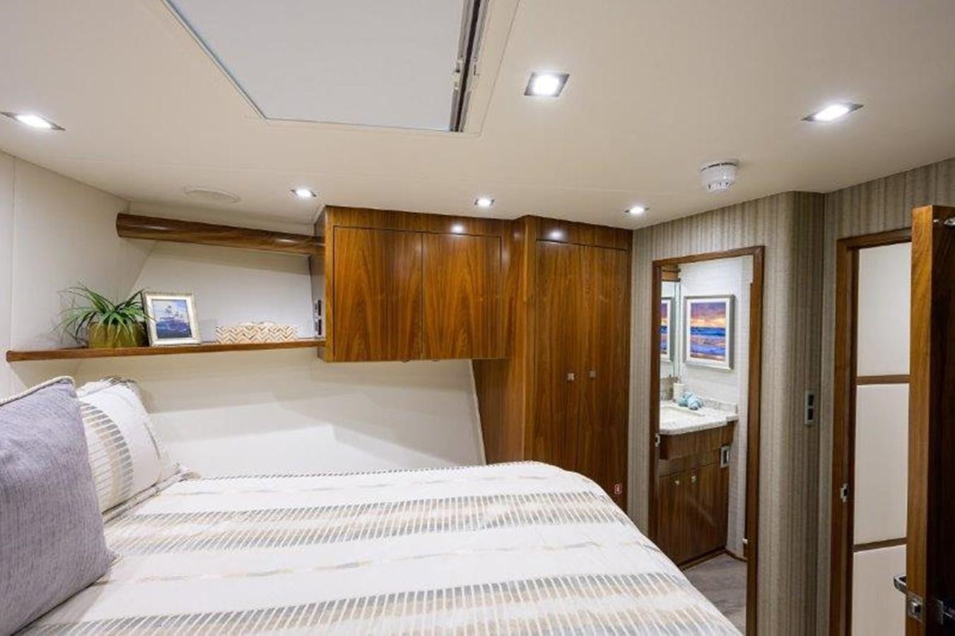 a bedroom with a bed and cabinets aboard 50 CALIBER Yacht for Sale