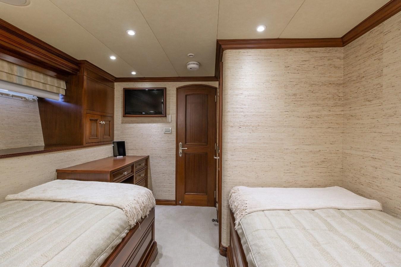 a room with a bed and a television aboard GITANA Yacht for Charter