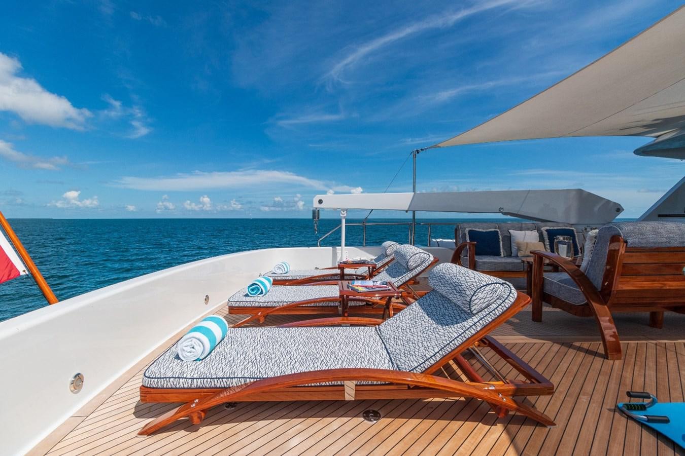 a deck with chairs on it by the water aboard GITANA Yacht for Charter