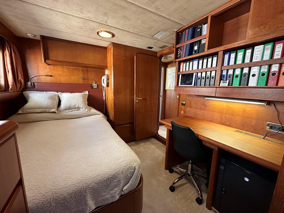 a room with a bed and desk aboard CHEETAH MOON Yacht for Sale