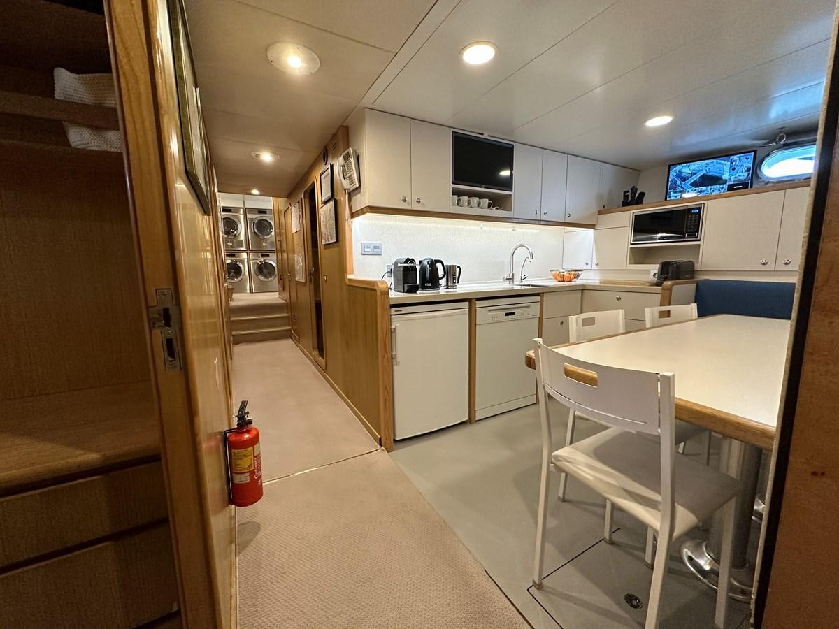 a kitchen with a table and chairs aboard CHEETAH MOON Yacht for Sale