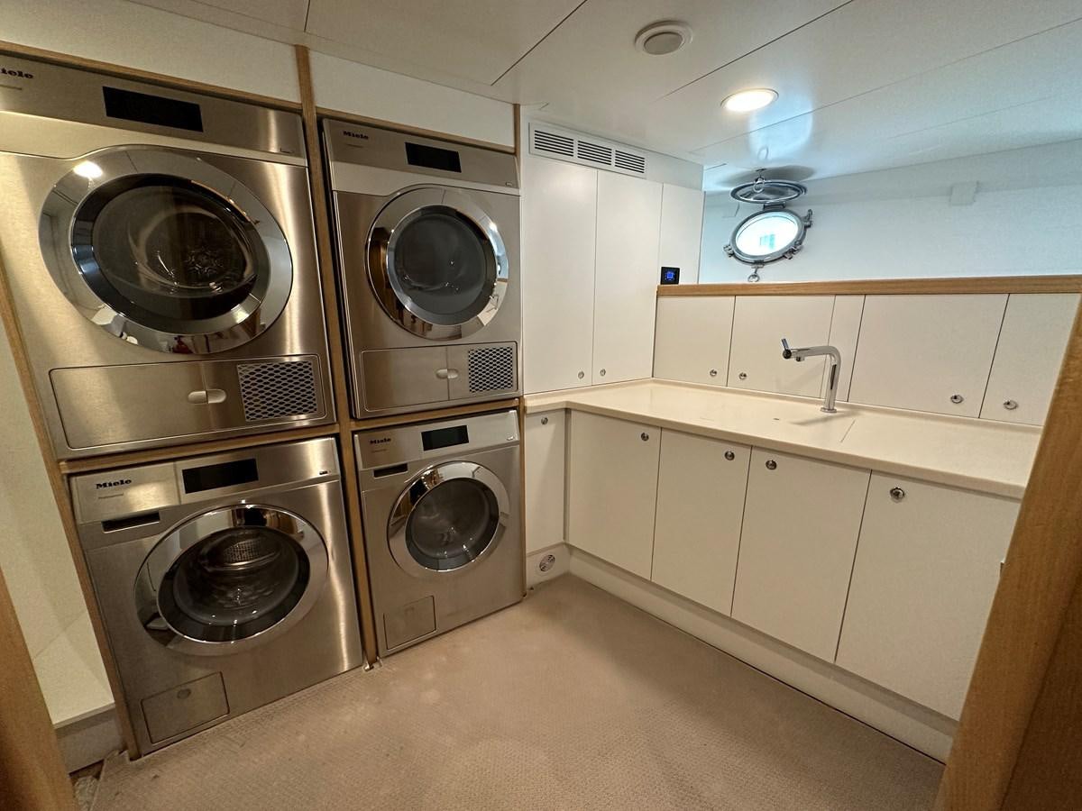 a room with white cabinets and a washing machine aboard CHEETAH MOON Yacht for Sale