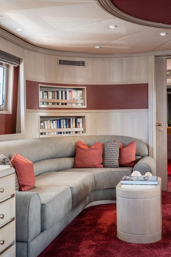 a living room with a couch and bookshelf aboard CHEETAH MOON Yacht for Sale
