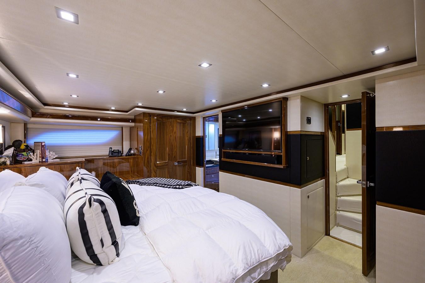 a room with a bed and a television aboard ENCLOSED BRIDGE Yacht for Sale