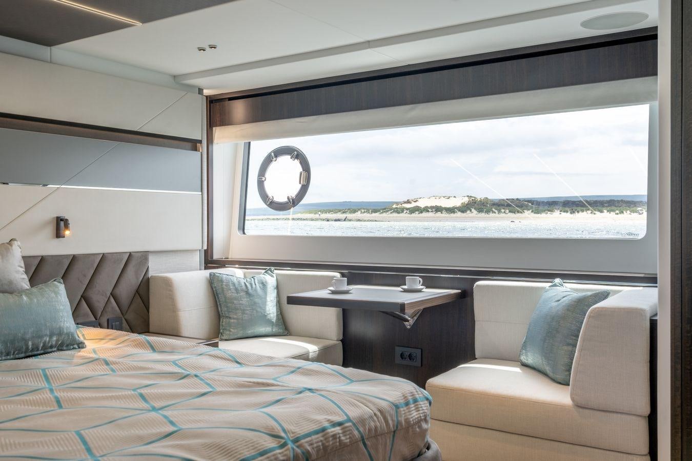 a room with a bed and a couch aboard PREDATOR 74 XPS Yacht for Sale