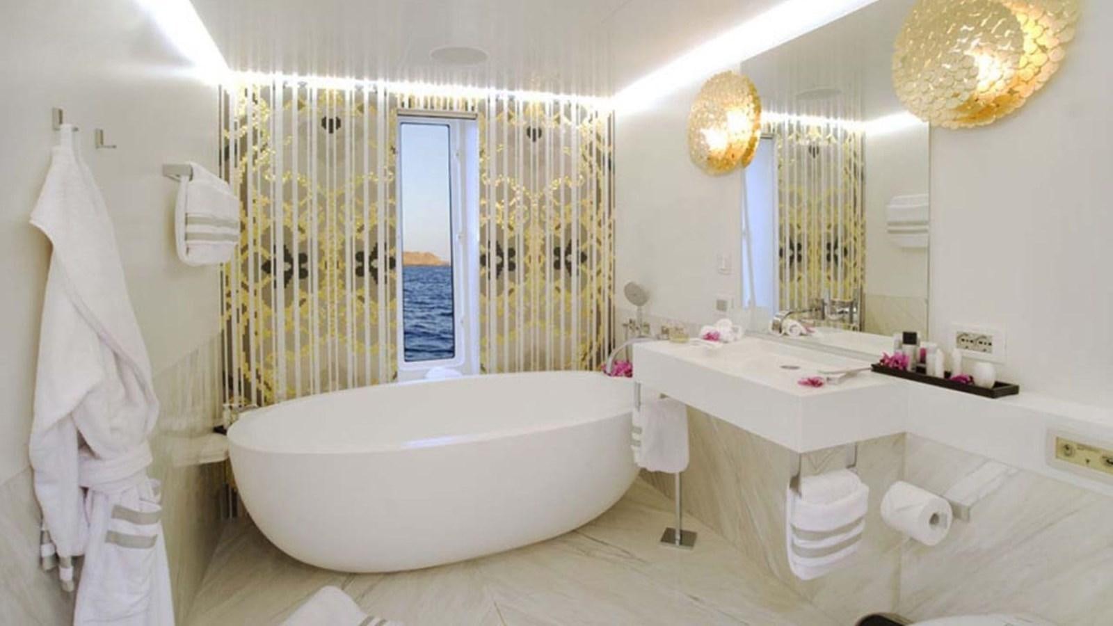 a bathroom with a bathtub and sink aboard BLADE II Yacht for Sale