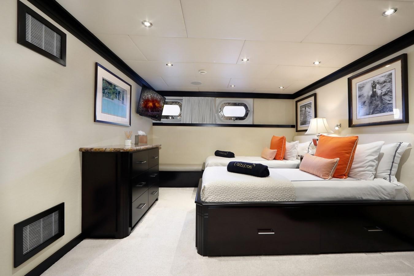 a bedroom with a bed and desk aboard L'ALBATROS Yacht for Charter