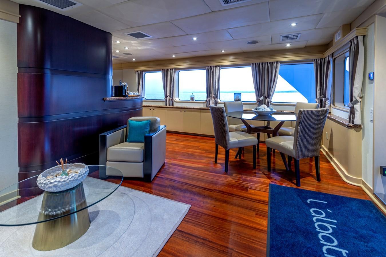 a room with a table chairs and a window aboard L'ALBATROS Yacht for Sale