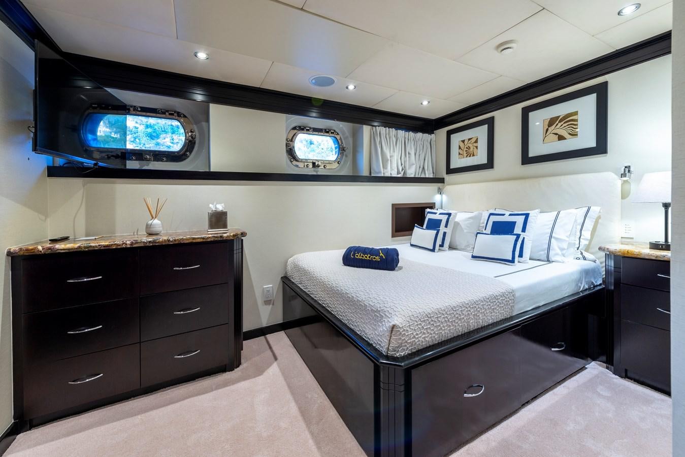 a bedroom with a bed and a tv on the wall aboard L'ALBATROS Yacht for Sale