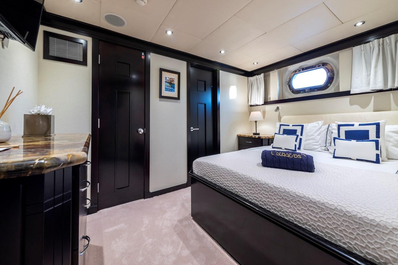 a bedroom with a bed and a desk aboard L'ALBATROS Yacht for Sale