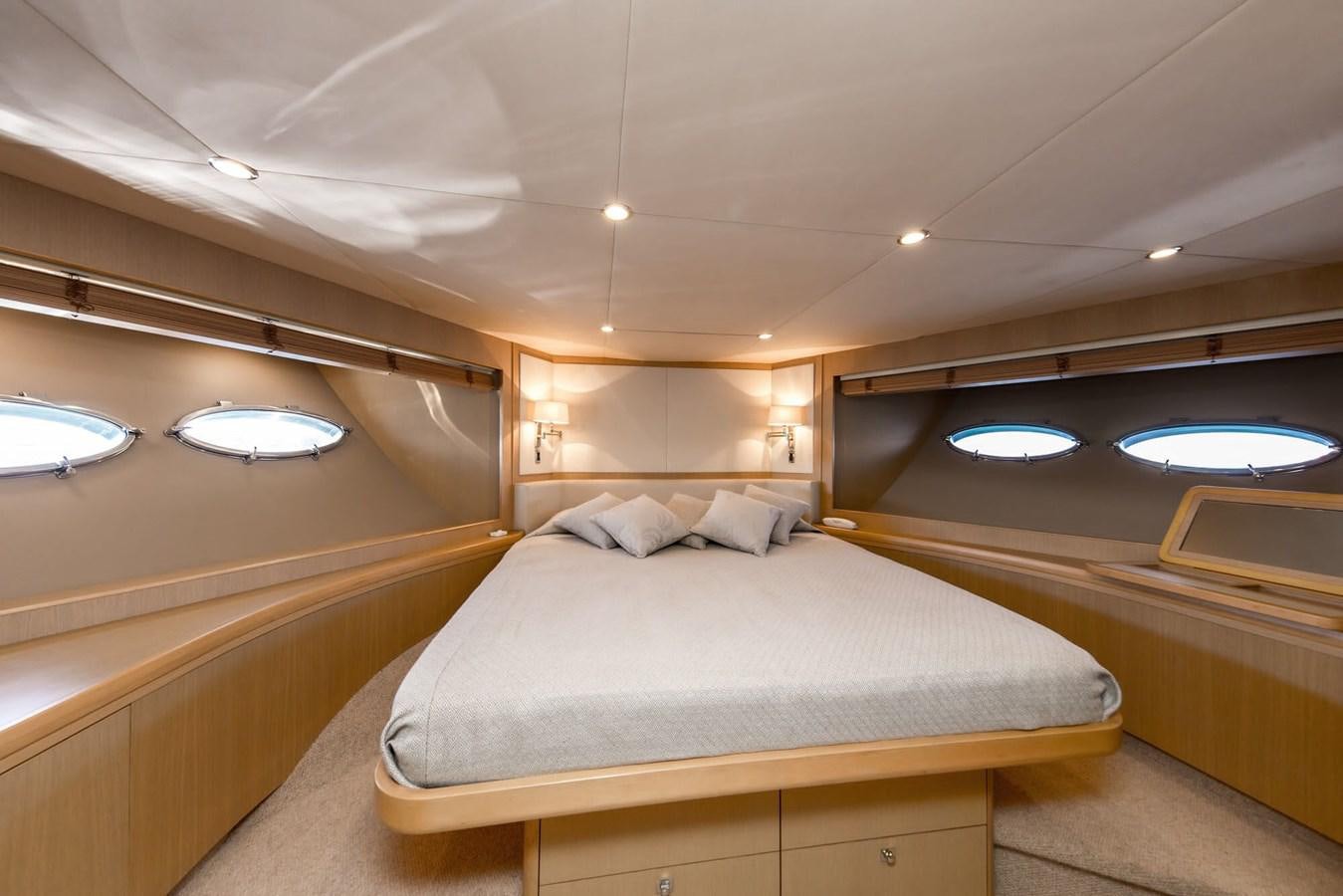 a room with a bed and a mirror aboard 2009 PRINCESS 85 Yacht for Sale