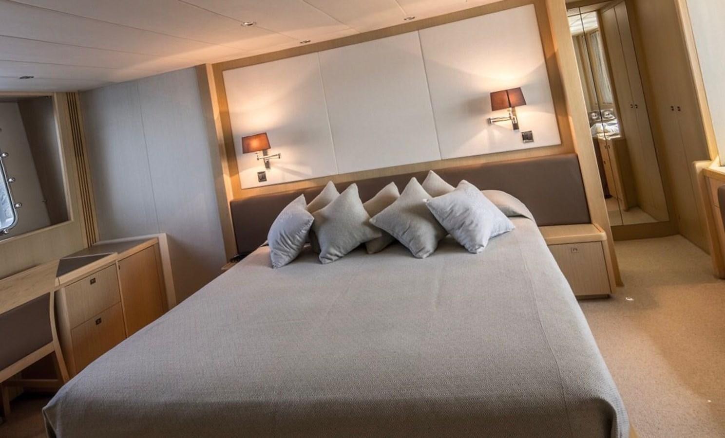 a bed with a blue comforter aboard 2009 PRINCESS 85 Yacht for Sale