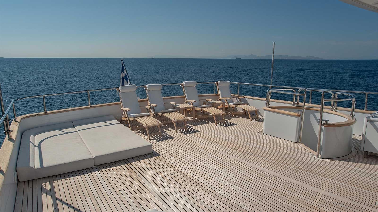 a deck with chairs and tables on it by the water aboard LET IT BE Yacht for Charter