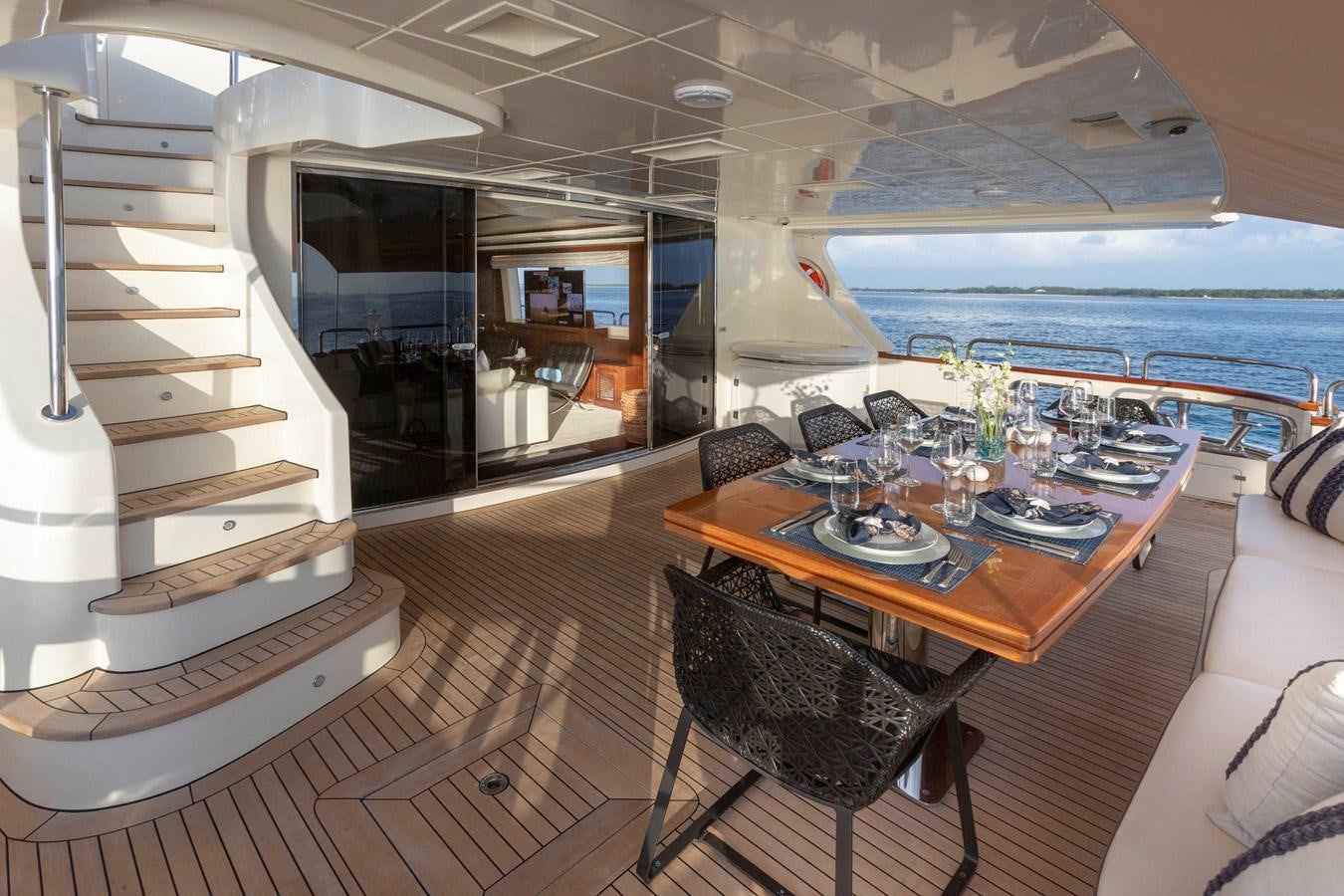 a dining table and chairs in a room with a large body of water aboard INSIEME Yacht for Sale