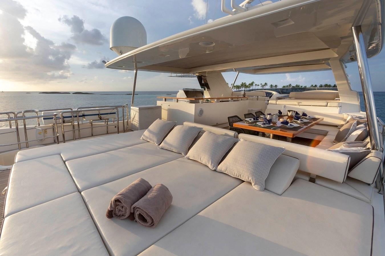 a large white lounge chair with a large white bed and a large window overlooking a large body of aboard INSIEME Yacht for Sale