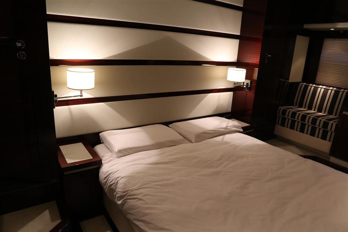 a bed with a white sheet and a black headboard aboard AMER 86 Yacht for Sale