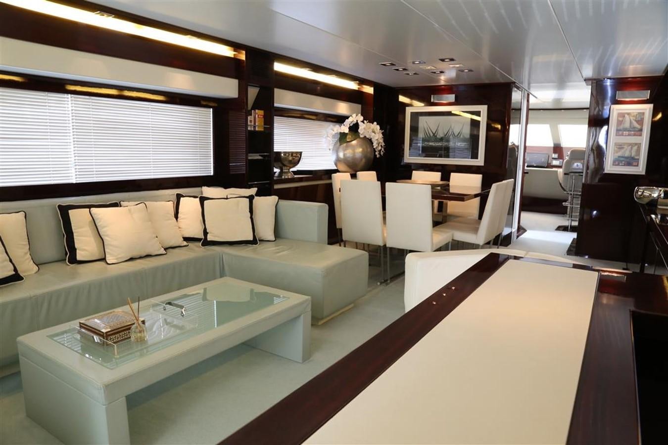 a living room with a large glass table and a large window aboard AMER 86 Yacht for Sale