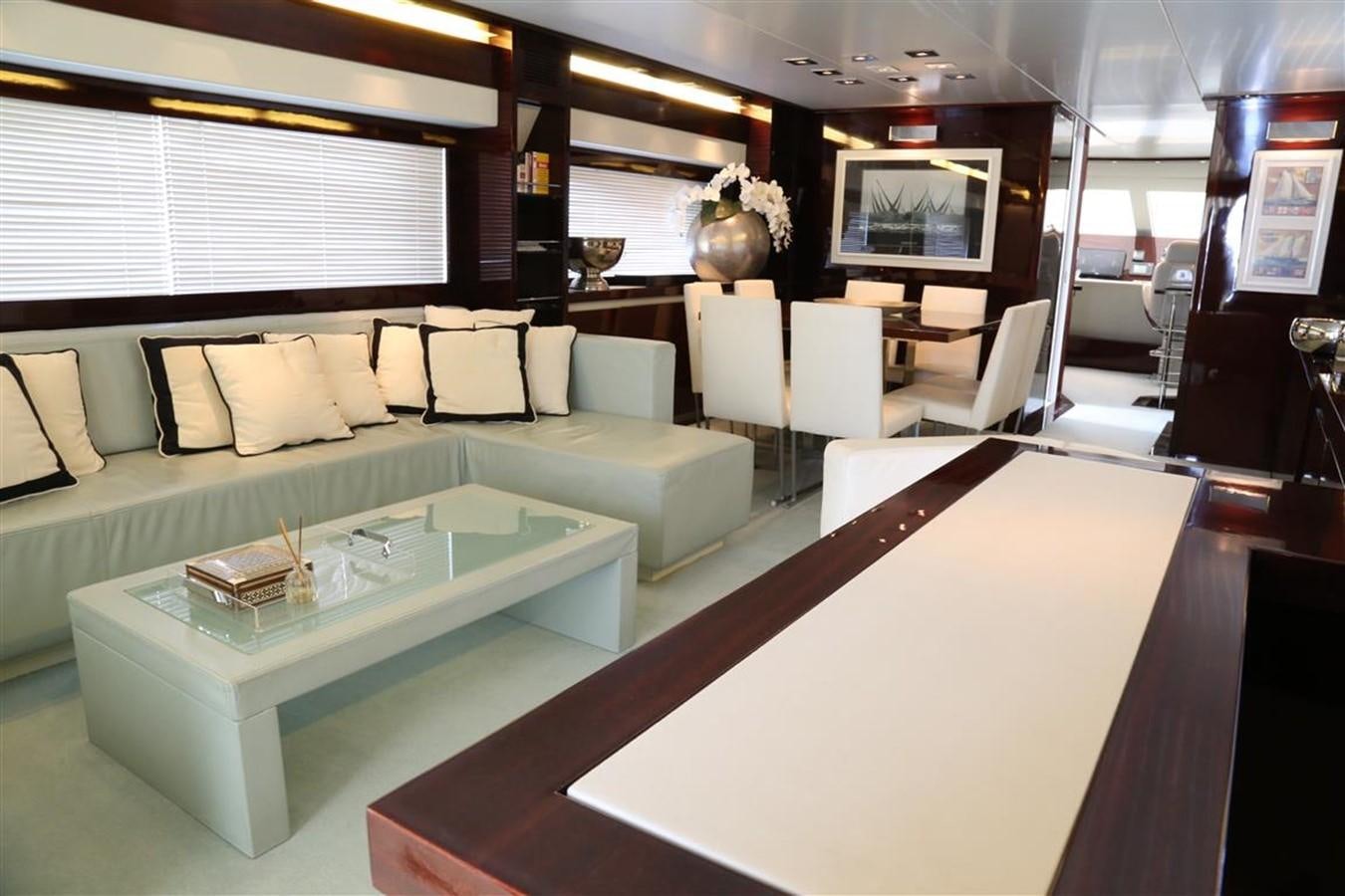 a room with a table and couches aboard AMER 86 Yacht for Sale