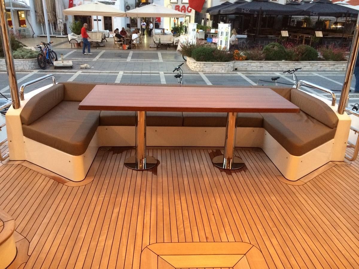 a table outside with benches aboard AZ84 Yacht for Sale