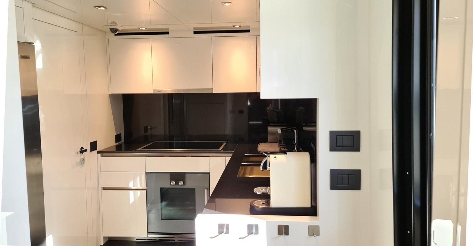 a kitchen with white cabinets aboard 2021 SANLORENZO SD96 #95 Yacht for Sale