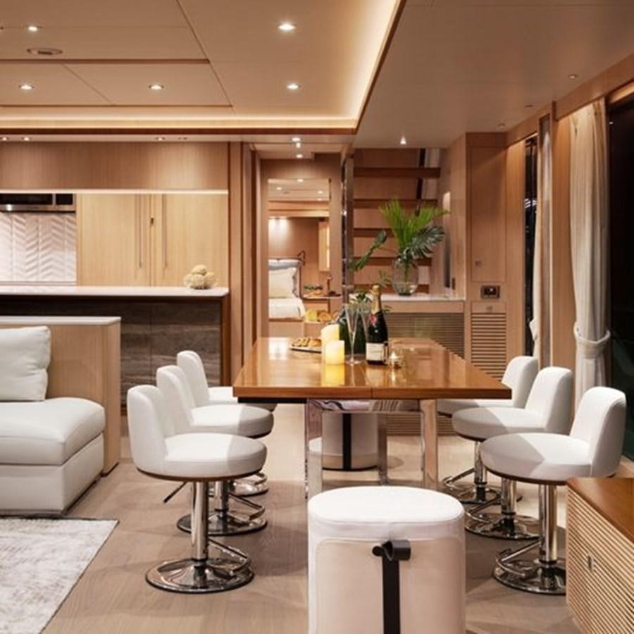 a modern looking kitchen with a dining table and chairs aboard ONE MORE TIME Yacht for Sale