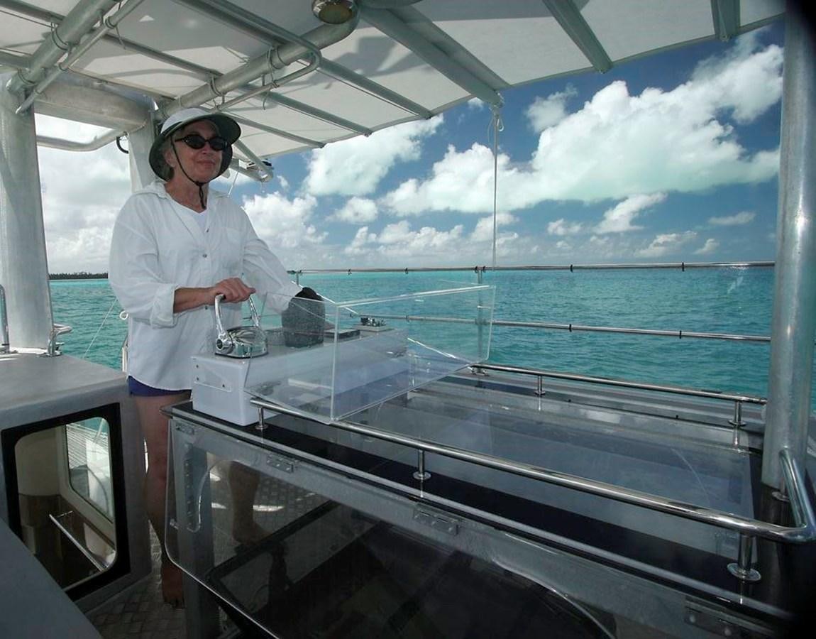 a man in a white coat standing on a boat aboard WIND HORSE Yacht for Sale