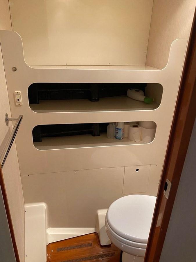a toilet with a shelf above it aboard WIND HORSE Yacht for Sale