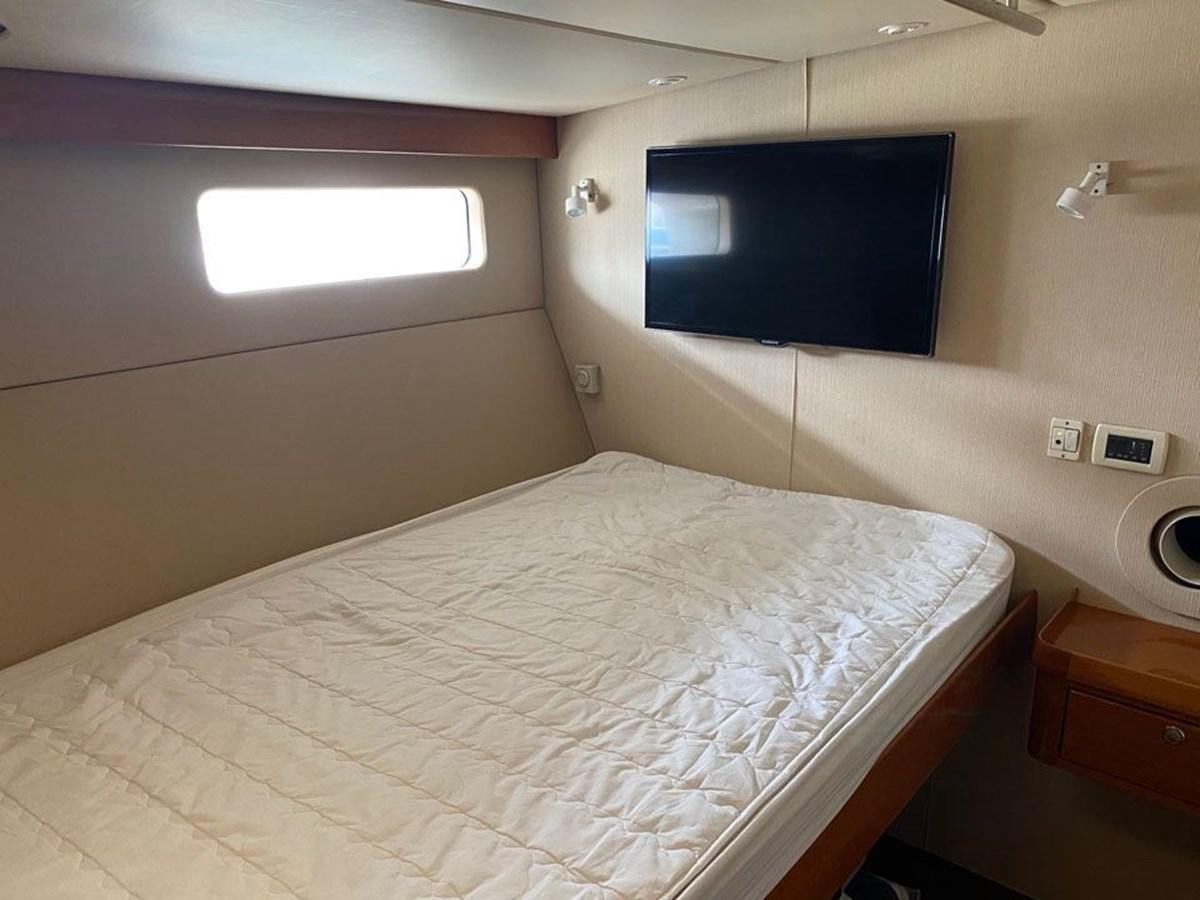a bed with a television on the wall aboard WIND HORSE Yacht for Sale