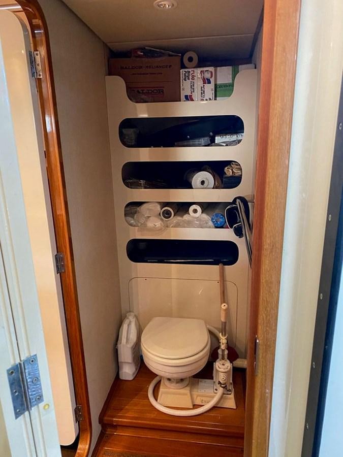 a toilet with a rack of clothes aboard WIND HORSE Yacht for Sale