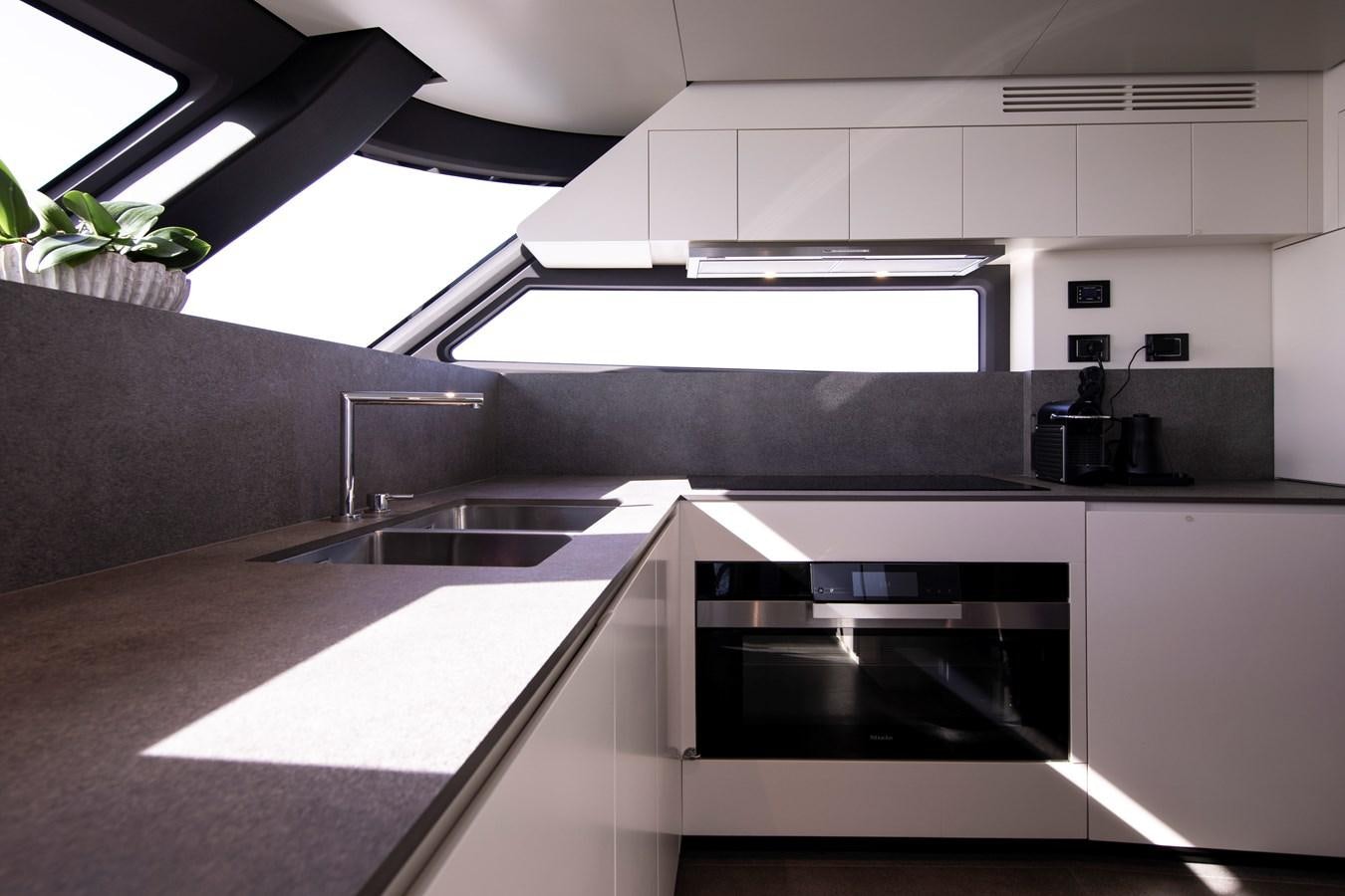a kitchen with white cabinets aboard ANDALA Yacht for Sale
