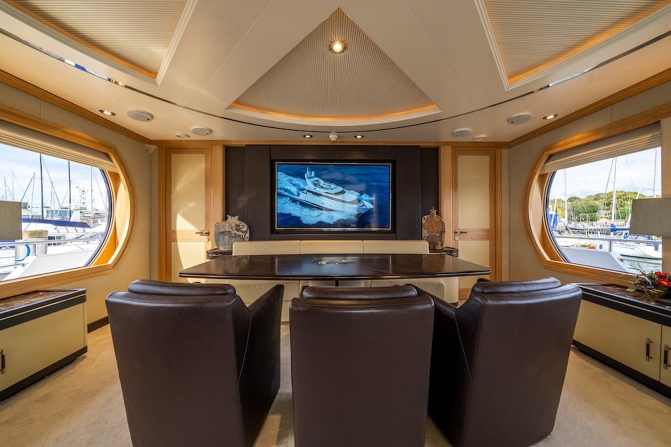 a room with a tv and chairs aboard LA MASCARADE Yacht for Sale