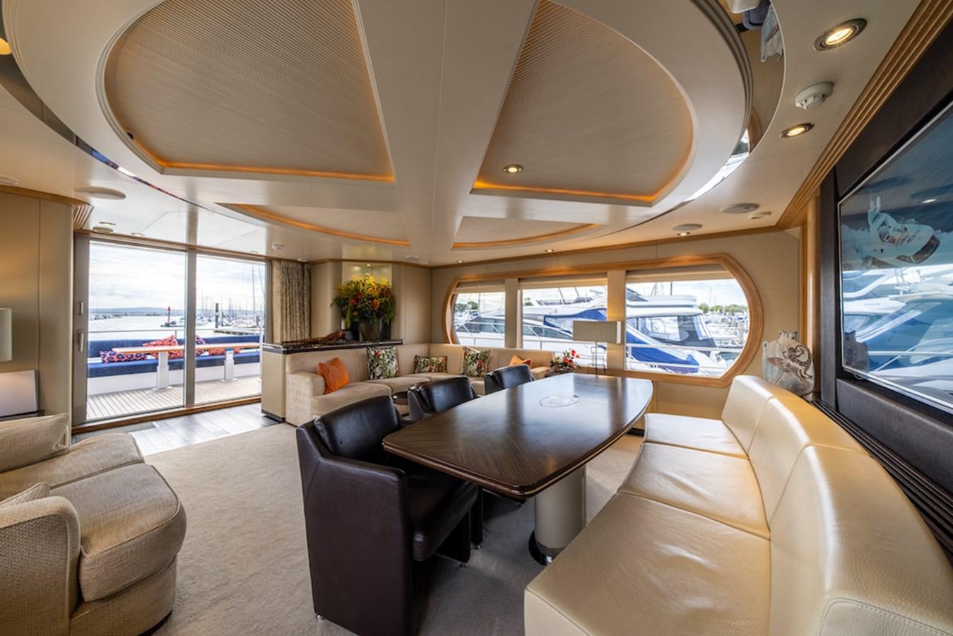 a room with a large window and a table with chairs aboard LA MASCARADE Yacht for Sale