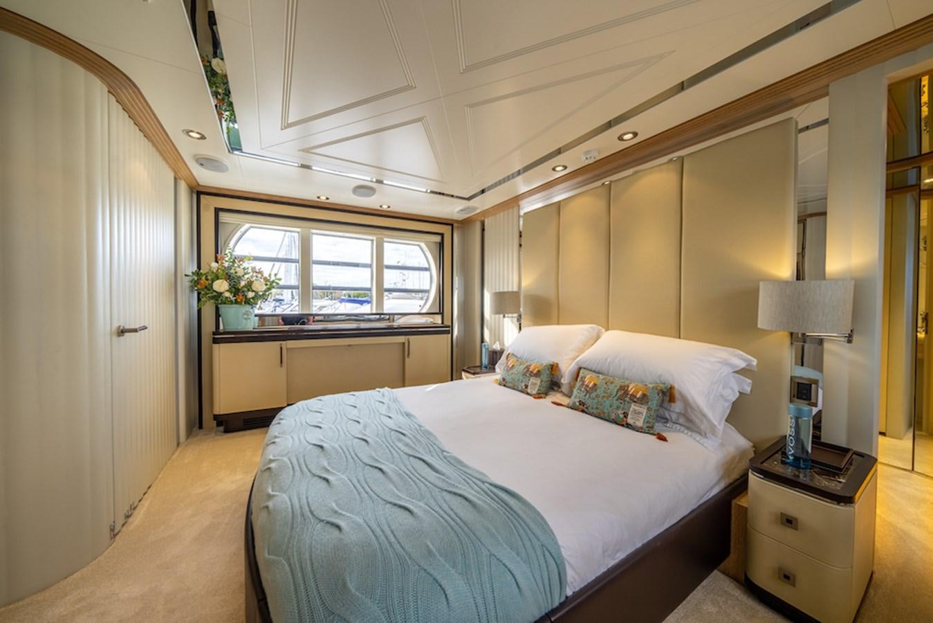 a bedroom with a bed and a window aboard LA MASCARADE Yacht for Sale
