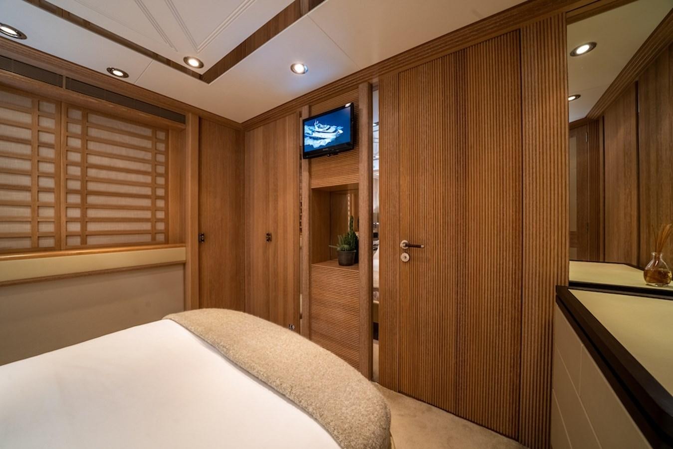 a room with a bed and a television aboard LA MASCARADE Yacht for Sale