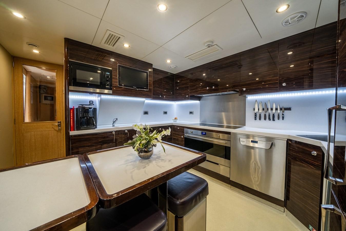 a kitchen with a table and chairs aboard LA MASCARADE Yacht for Sale