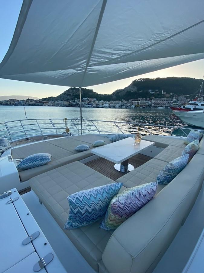 a large white lounge chair on a deck overlooking a body of water aboard FREE MIND Yacht for Sale