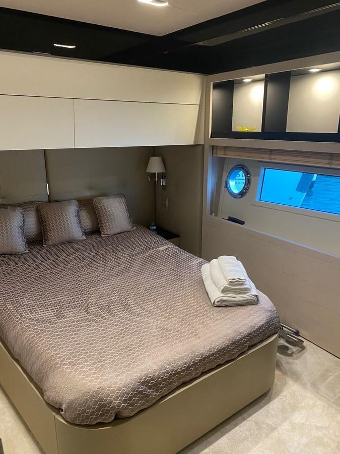 a bed with a pillow and a television on the wall aboard FREE MIND Yacht for Sale