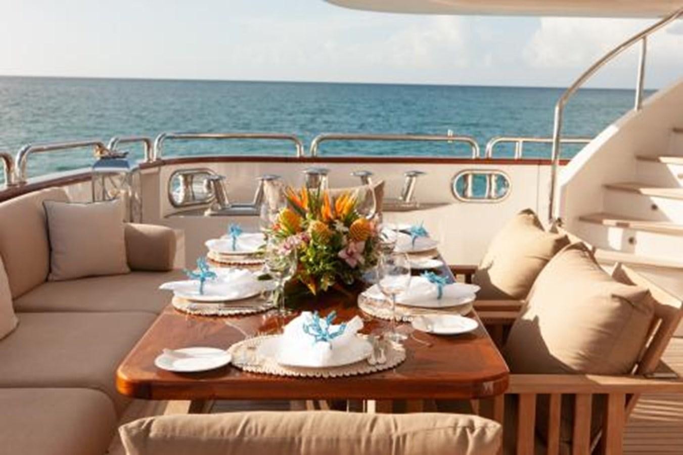 a table with plates and flowers on it aboard SUR LA MER Yacht for Sale