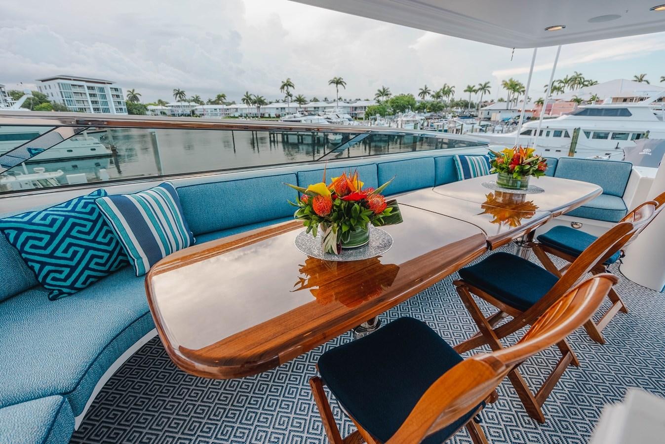 a table with chairs and a couch aboard LA LADY Yacht for Sale